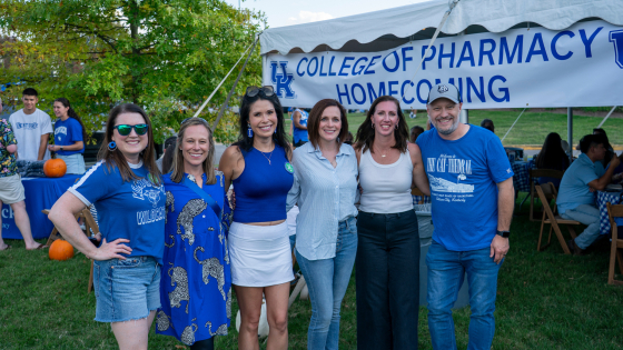 A group of people pose together at a homecoming tailgate