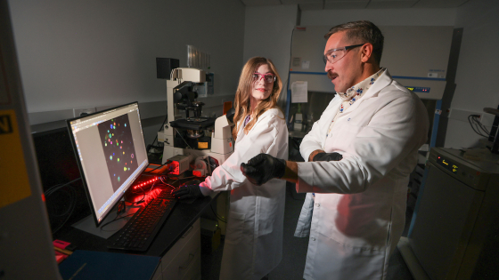 two scientists examining something on a computer screen