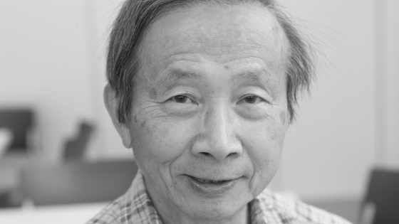 A man wearing a collared shirt smiling at the camera