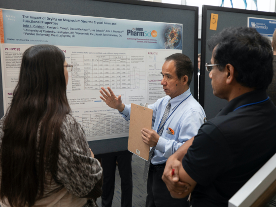 faculty member talking with poster presenter