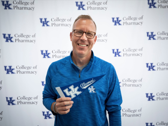 Craig martin holding blue UK alumni flag