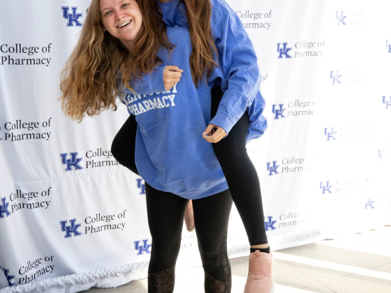 female students piggy-back smiling