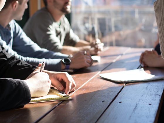 people sitting at table with notebooks