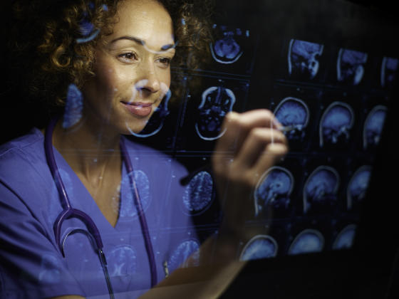 person in scrubs looking at brain scans