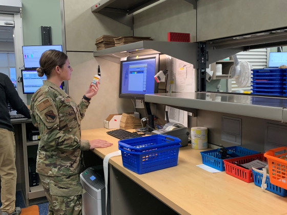 woman standing in camo looking at medication bottle