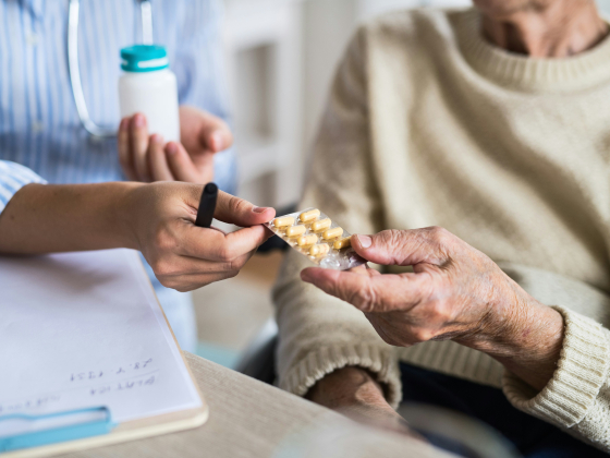 someone handing another person a pack of pills