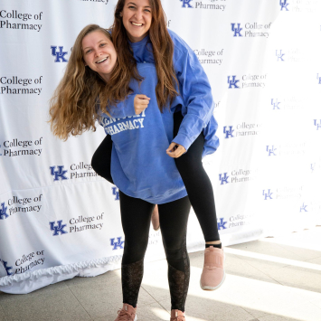 female students piggy-back smiling