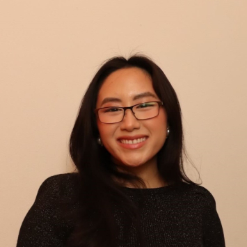 Woman wearing a black shirt and glasses and smiling