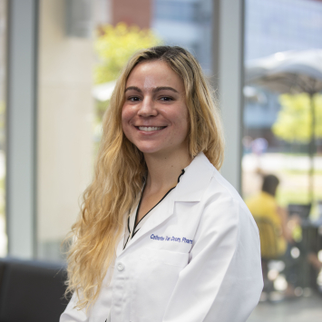 Woman wearing white lab coat smiling