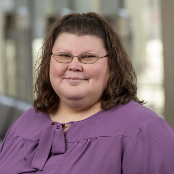 a woman wearing glasses smiling
