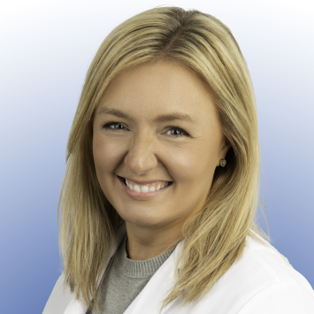 a blonde woman wearing a white coat with the Primary Plus logo