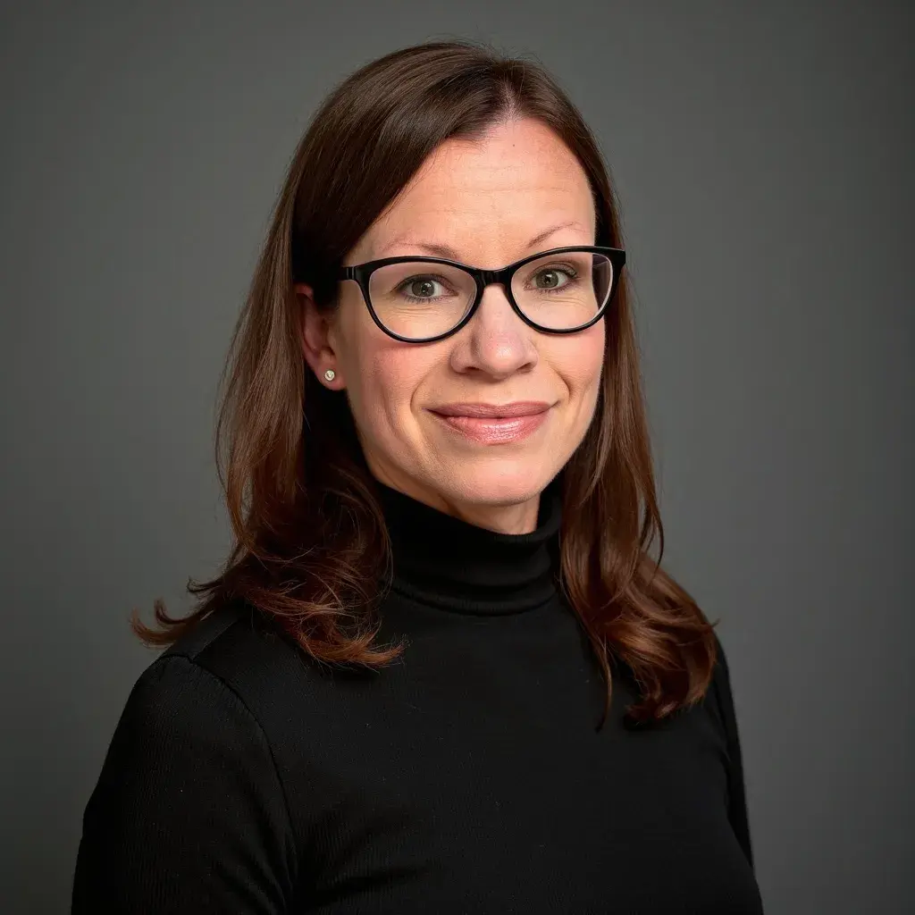 woman wearing turtleneck and black rimmed glasses smiling
