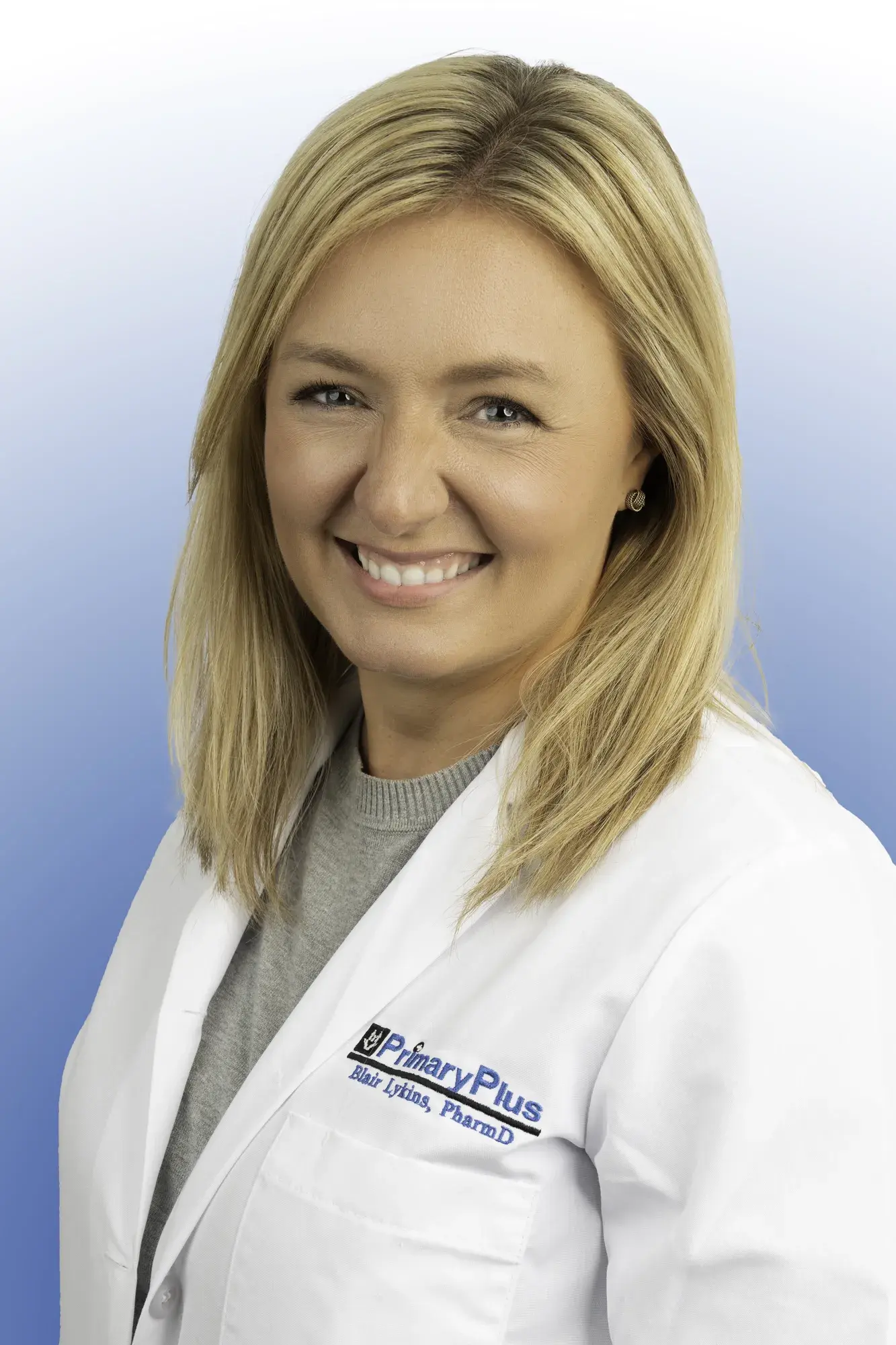 a blonde woman wearing a white coat with the Primary Plus logo